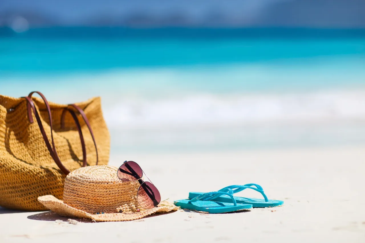 Straw bag with sunglasses on beach