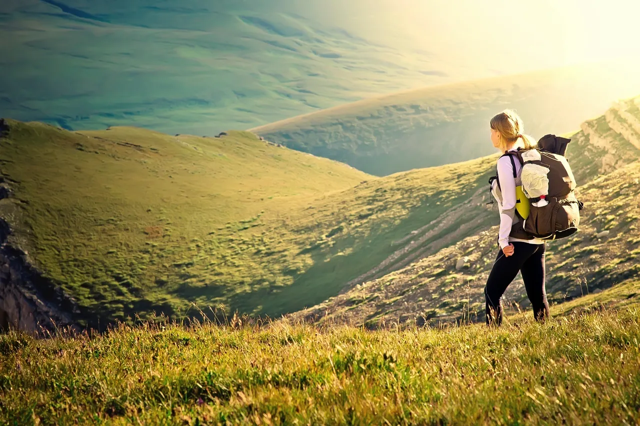 Backpacker on grassy hilltop