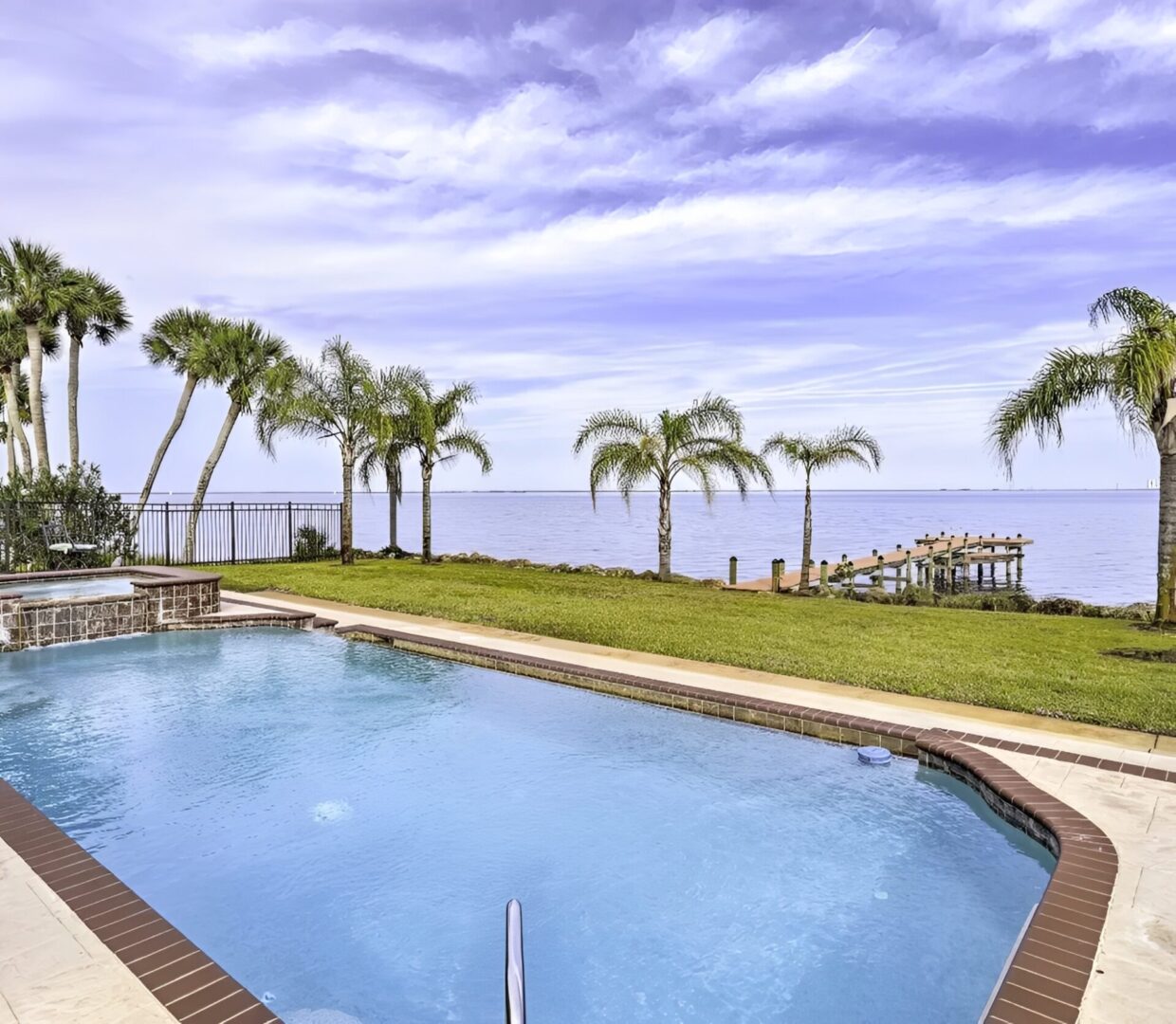 Poolside view with palm trees and ocean